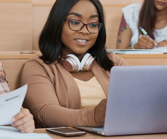 Studentin prüft Unterlagen am Laptop zur Vorbereitung ihres Visumantrags